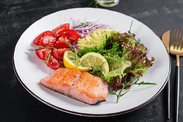Teller mit gesundem Essen, Salat, Fisch