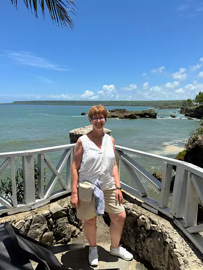 Frau auf Terrasse mit Meer im Hintergrund