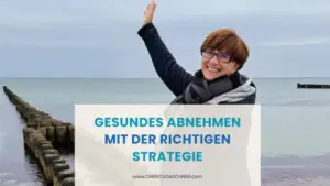 Frau steht an einer Buhne am Meer