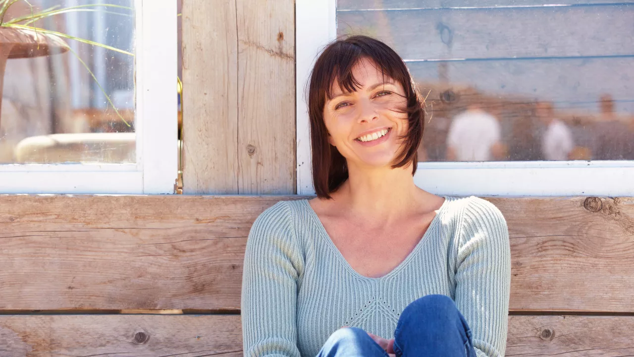 Frau entspannt auf einer Bank vor dem Haus - emotionales Essen als selbstsabotage - nervensystem beruhigen - christadaschner.com