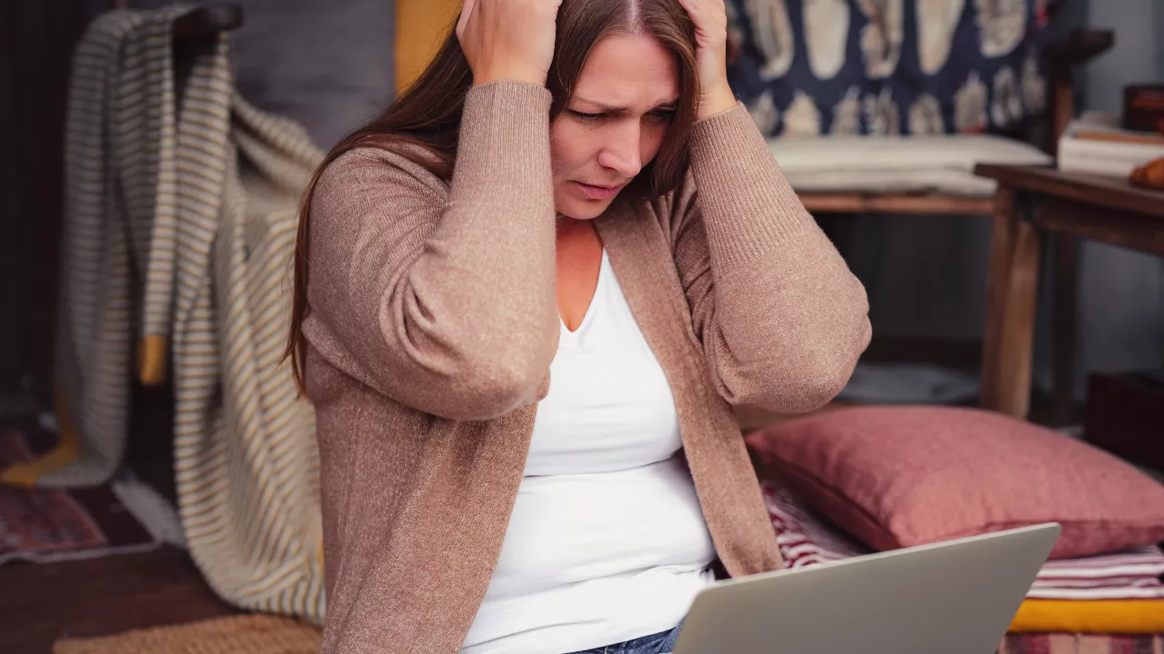 Frau sitzt mit Laptop und ist frustriert und gestresst - emotionales essen - christa daschner